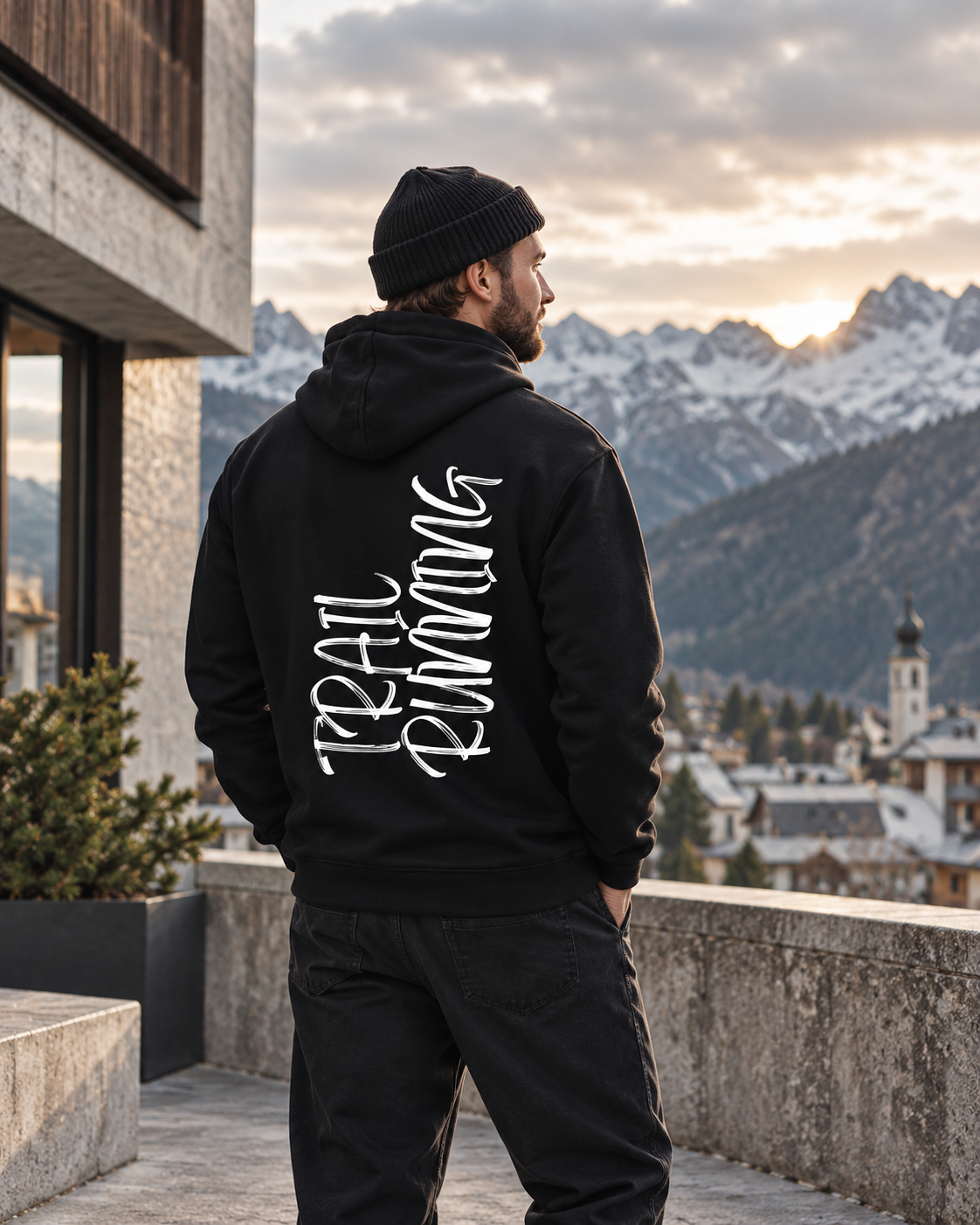 Mann im schwarzen Trailrunning vertikal Hoodie im urban-alpinen Streetwear-Setting